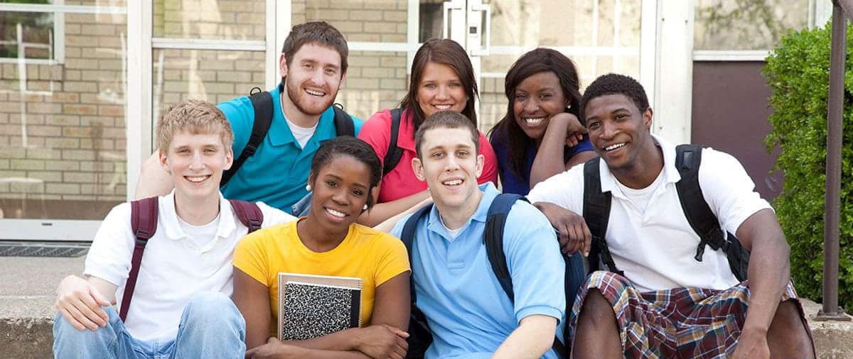 Image: Group of college students sitting on steps in front of building