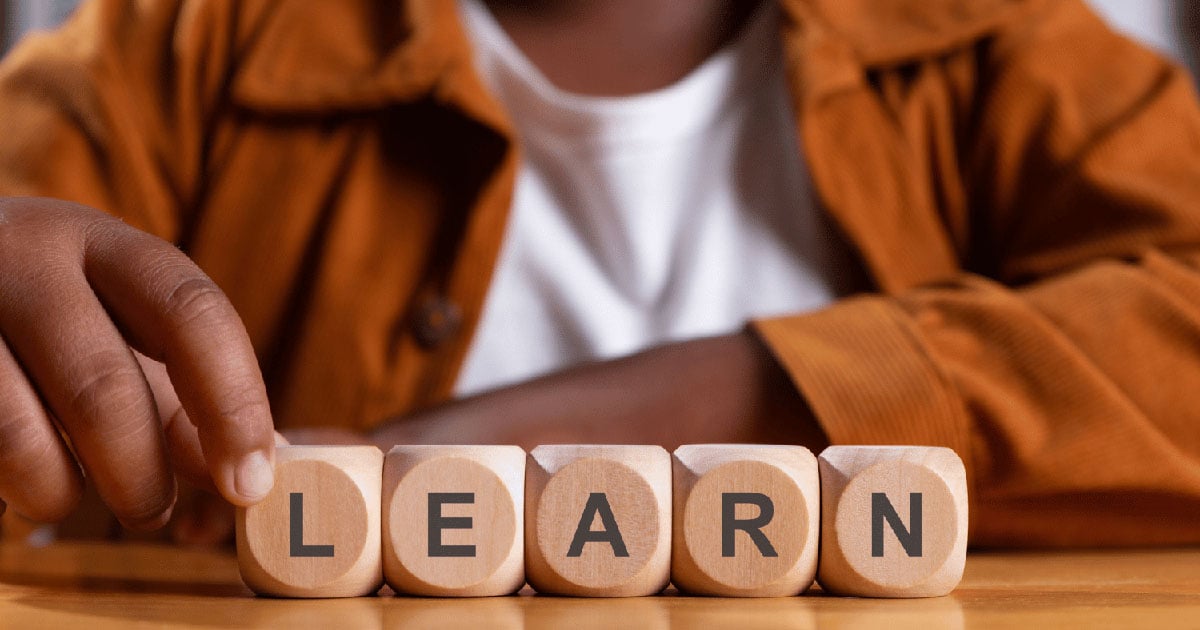 Child and letter blocks spelling LEARN