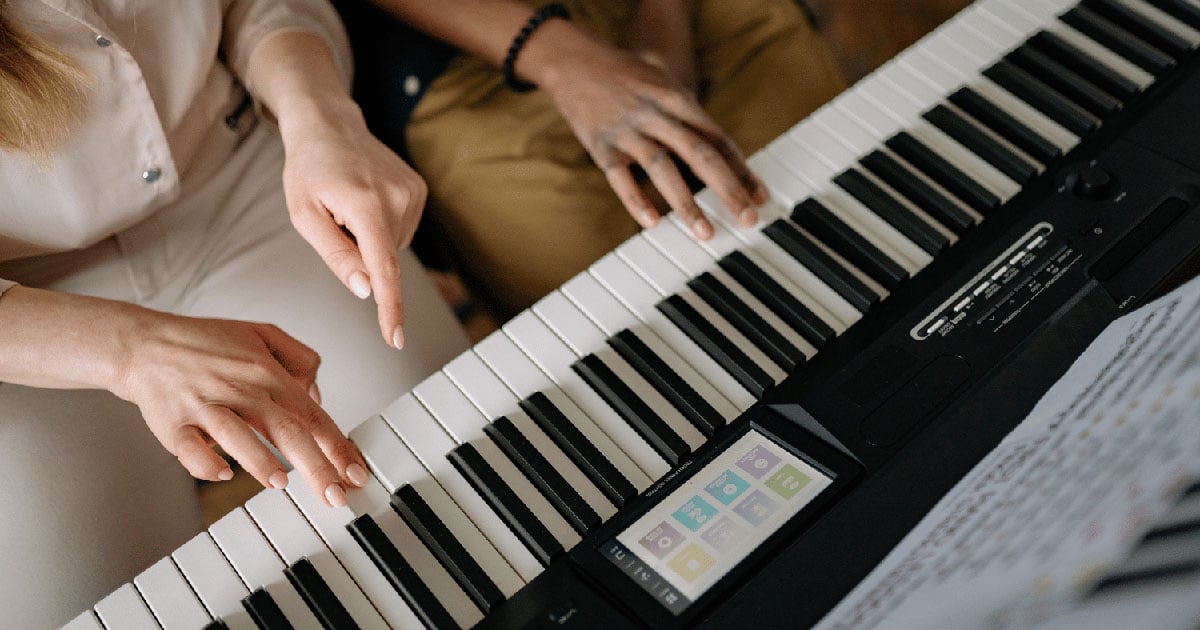 Image: Mom helping child practice piano
